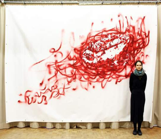 L'artiste Camille Bleu-Valentin pose devant son oeuvre Monumentoile "Departed"